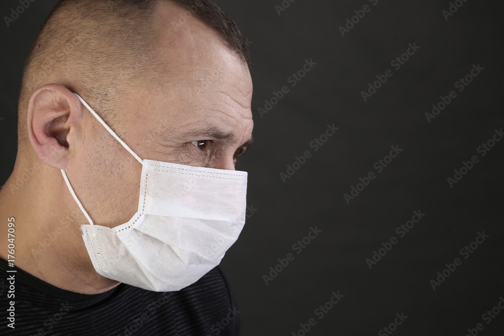 man in a black T-shirt and a medical mask man in a black T-shirt and a medical mask