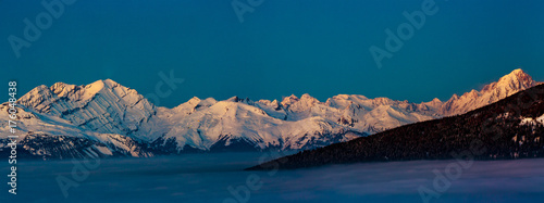 Scenic panorama sunset landscape of Crans-Montana range in Swiss Alps mountains with peak in background, Crans Montana, Switzerland.