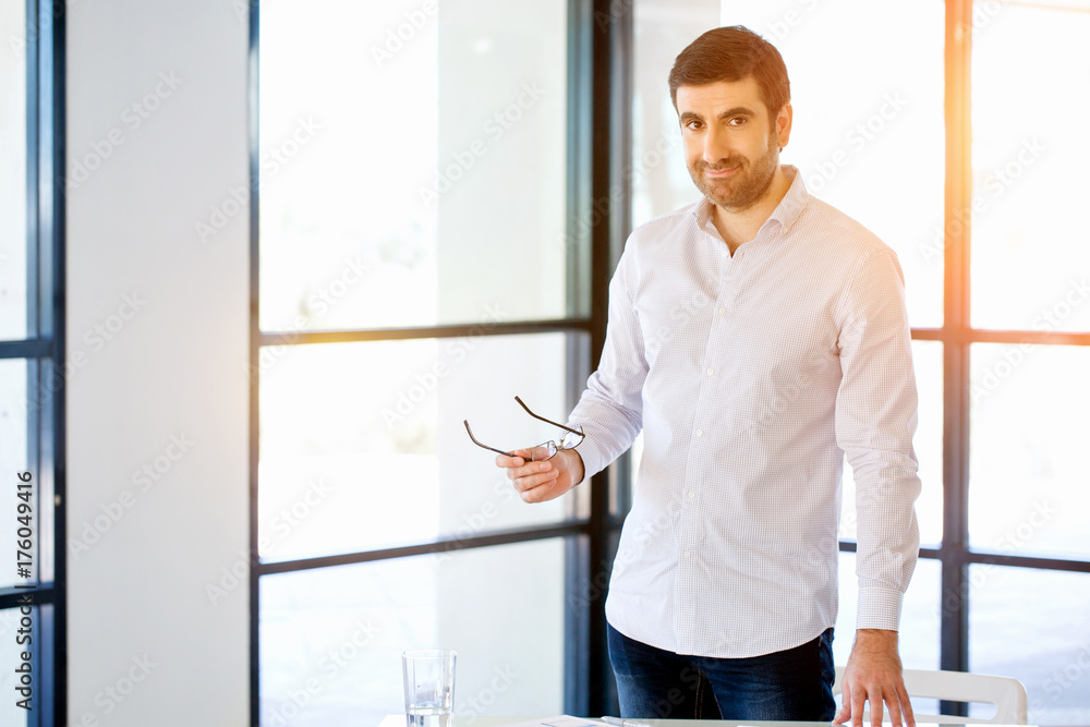Fototapeta premium Young caucasian businessman standing in office