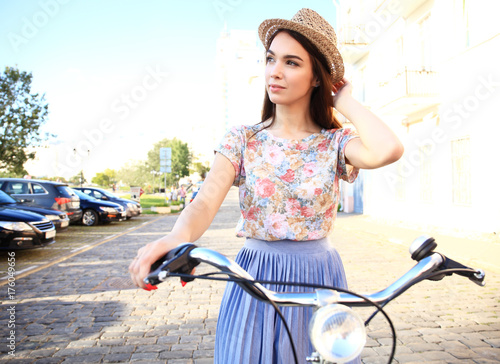 Charming woman on bike in city, during summer photo