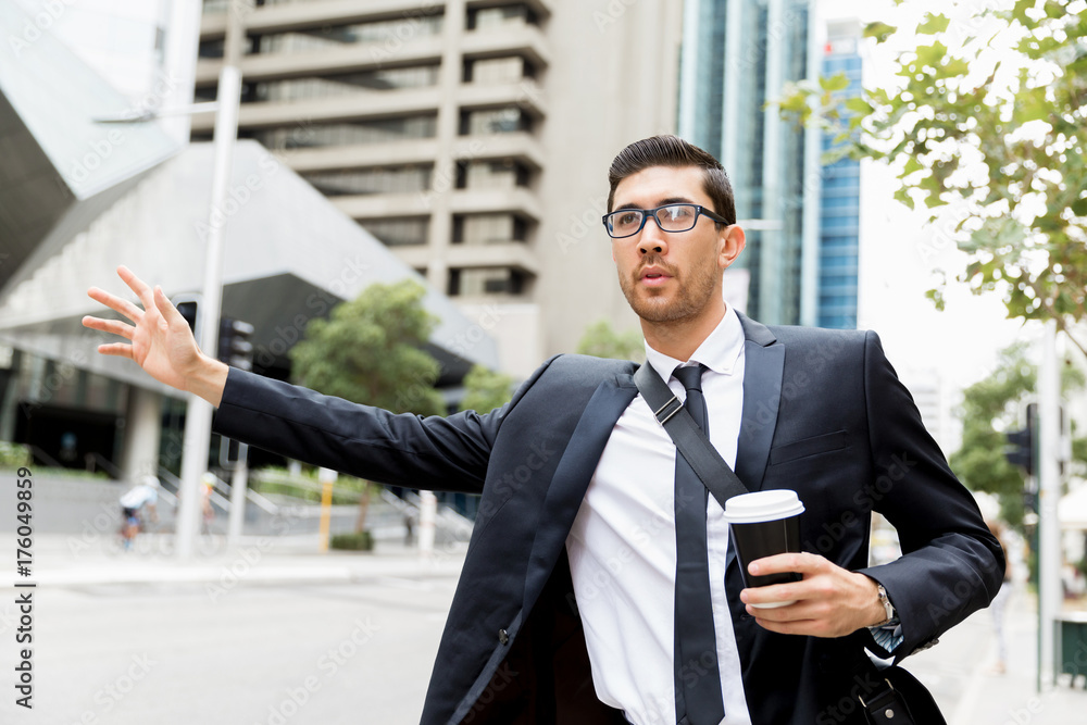 Young businessman hailing for a taxi Young businessman hailing for a taxi