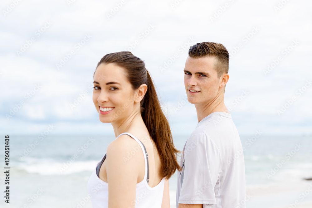 Fototapeta premium Young couple looking thoughtful while standing next to each other on beach