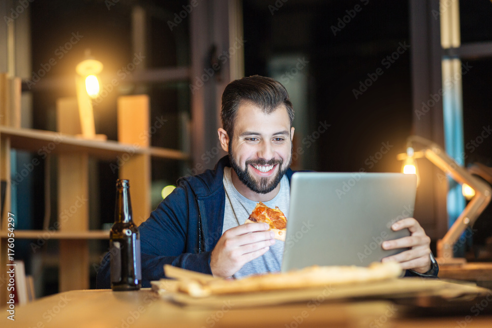 Fototapeta premium Handsome man smiling while eating
