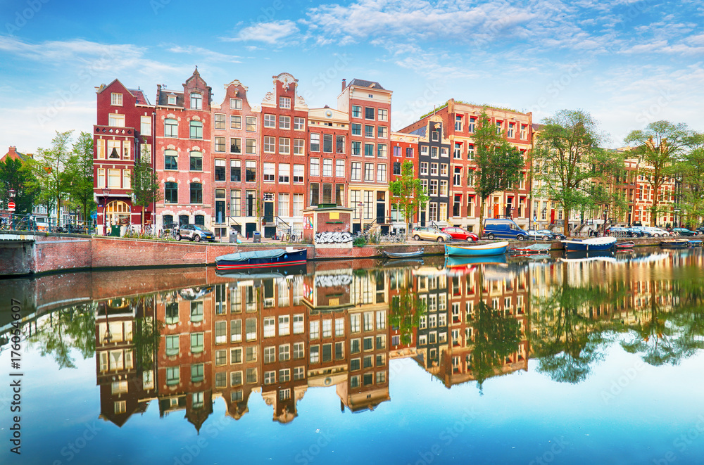 Fototapeta premium Tradycyjne holenderskie stare domy nad kanałami w Amsterdamie, Holandia.