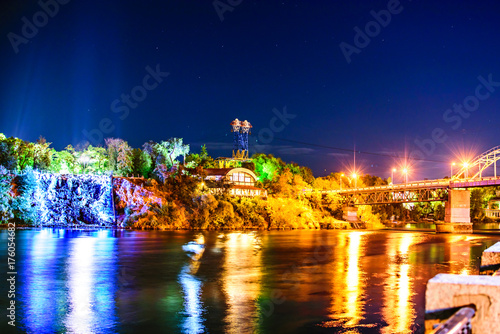 Night view of an Artificial Waterfall and pedestrian bridge on Monastyrsky Island in the city of Dnepr on the river.. Dnepropetrovsk, Dnipropetrovsk, Dnipro city, Ukraine photo