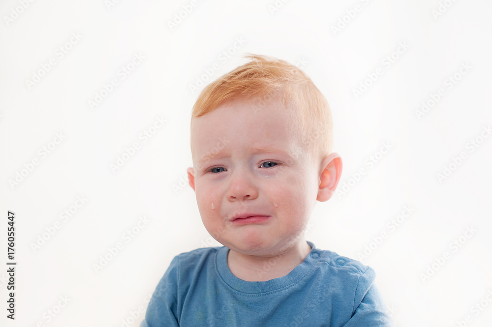 Offended and upset the baby cries on white background Offended and upset the baby cries on white background