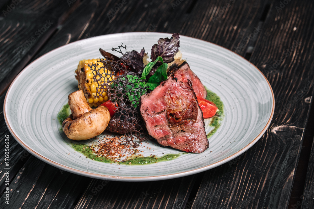 Grilled beefsteak with vegetable on dark wooden background Grilled beefsteak with vegetable on dark wooden background