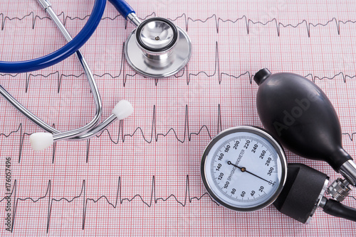 Sphygmomanometer with aneroid gauge and stethoscope with Electrocardiogram paper. photo