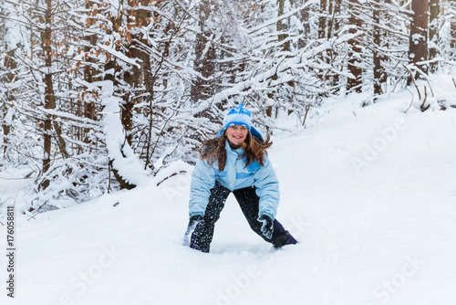 girl enjoying day playing in winter forest