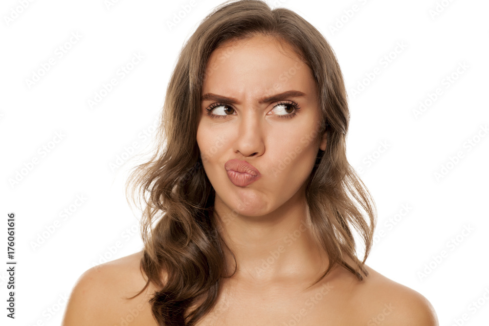 Portrait of beautiful young scowling woman on white background Portrait of beautiful young scowling woman on white background