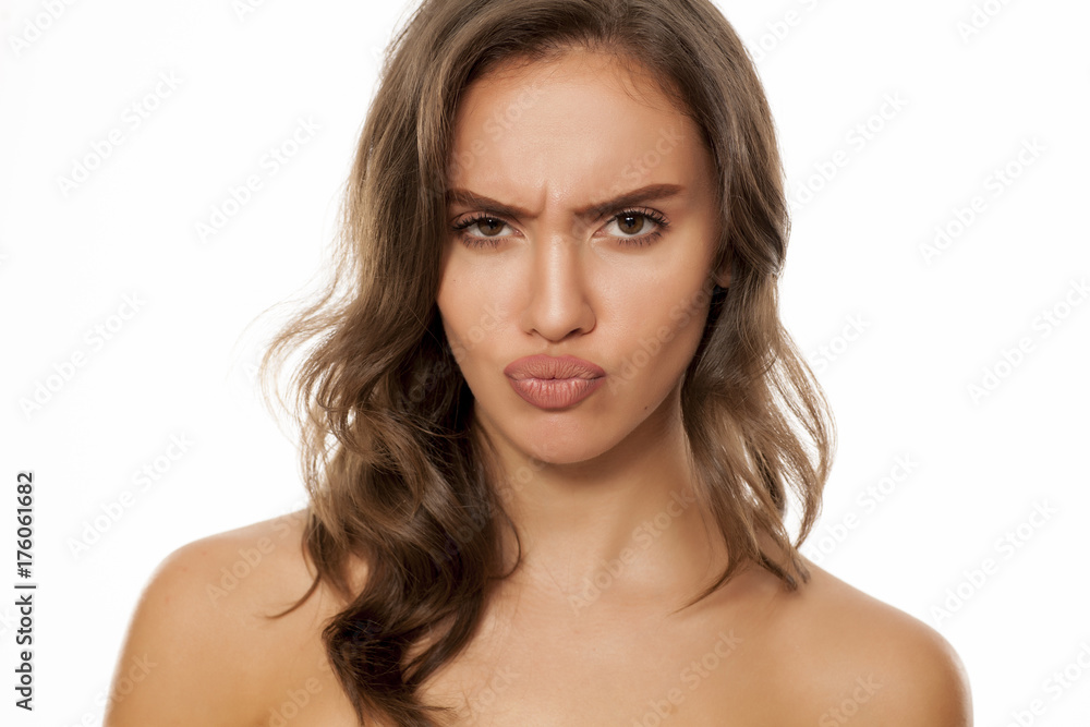 Portrait of beautiful young scowling woman on white background Portrait of beautiful young scowling woman on white background