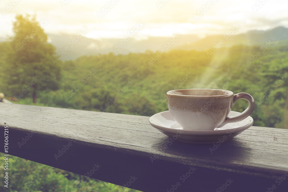 coffee cup on wood balcony in the morning with mountain view.