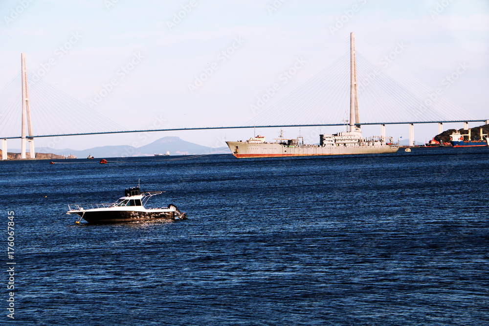 RUSSIA, VLADIVOSTOK, 27.09.20017. View on Golden brige in Vladivostok city with a ship and little yacht in the bay.