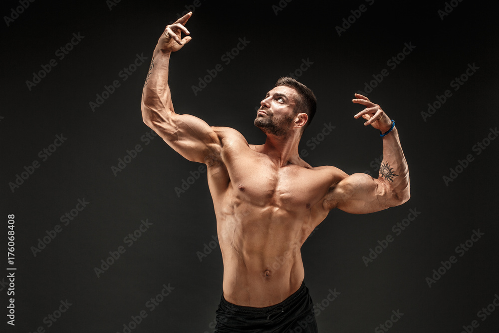 Muscular and good shaped young bodybuilder poses over the wall Stock Photo  | Adobe Stock