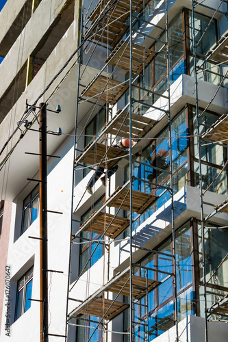 Working in a helmet on the scaffolding during the construction of high-rise residential buildings