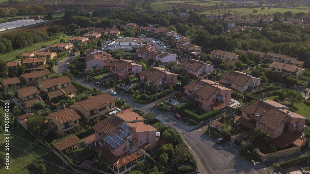 Vista aerea di un complesso residenziale costituito da ville indipendenti e tanti alberi e giardini. Tra il verde della natura spicca il rosso dei tetti fatti con tegole.