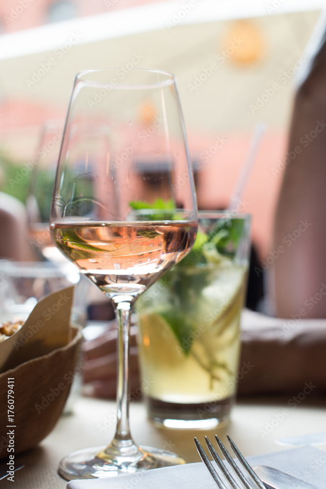 A glass of rose wine and mojito cocktail for hot summer day, romantic dinner for two, fresh aperitif on restaurant table