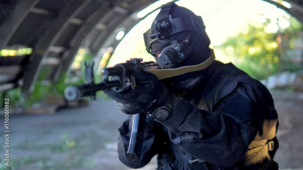 Soldier in modern ammunition walks and aims in front of him during military operation. 4K. Soldier in modern ammunition walks and aims in front of him during military operation. 4K.