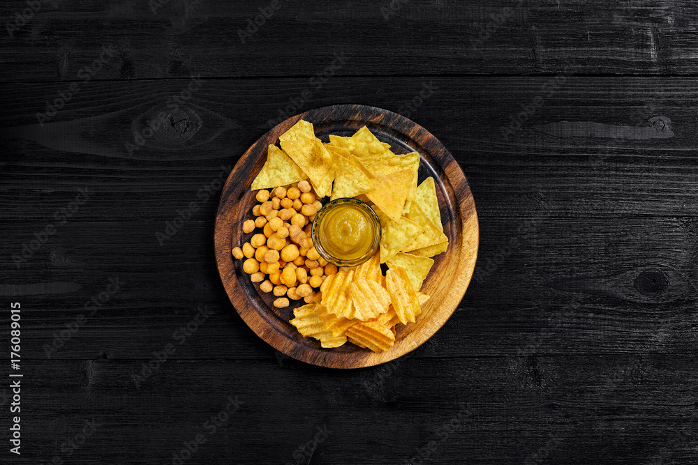 Overhead view of snacks with sauce on black wooden table. Overhead view of snacks with sauce on black wooden table.