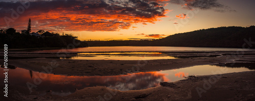 Red and gold sky of sunset reflected in the Gonubie river near East London, South Africa photo