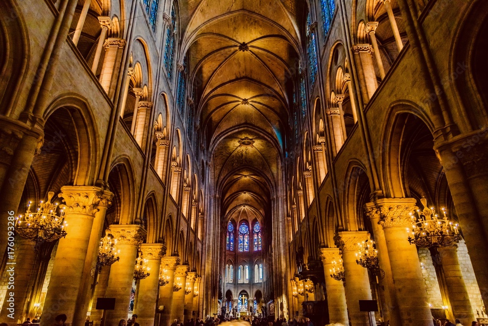mystical image of the interior of Notre Dame cathedral In Paris with candles of lit faithful illuminated by colored stained glass windows - obrazy, fototapety, plakaty 