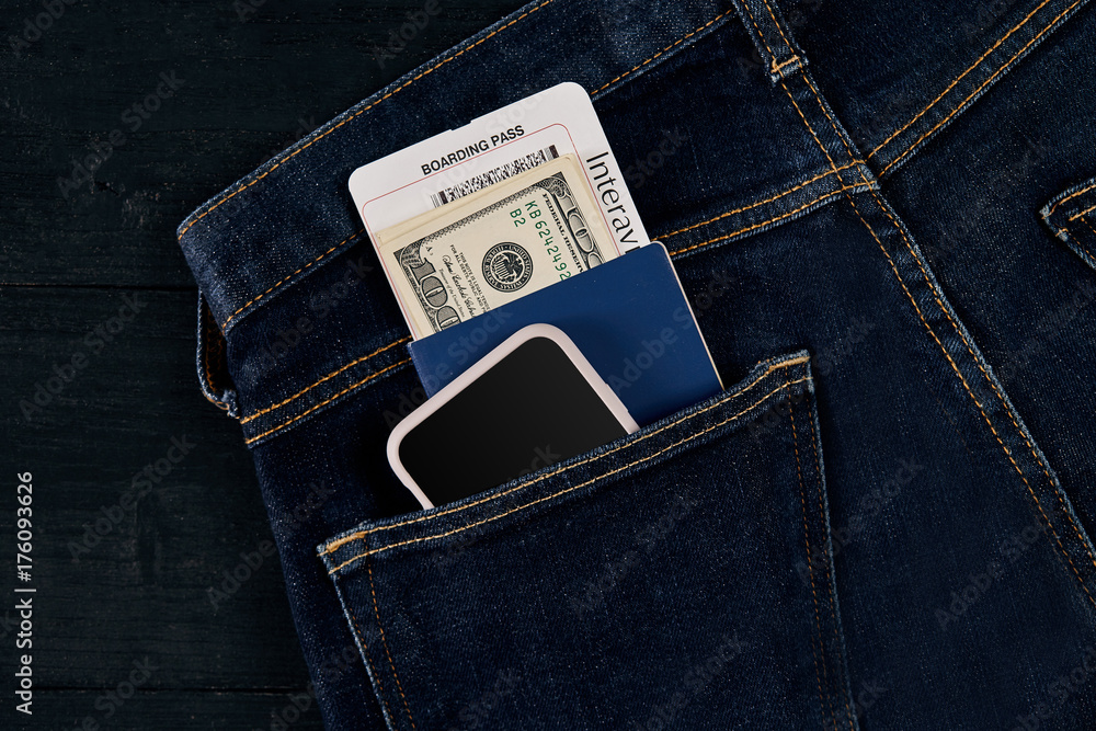 Dollars, smart, passport and plane ticket in your pocket jeans. Dollars, smart, passport and plane ticket in your pocket jeans.