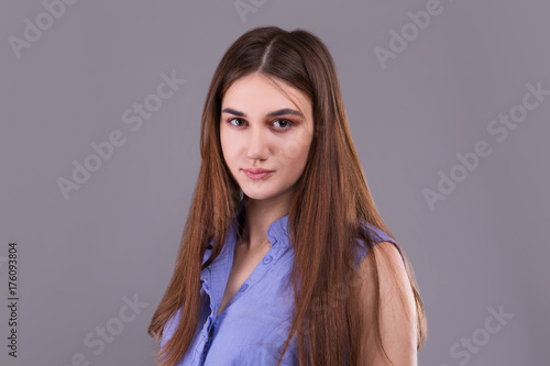 Portrait of cute fashionable young brunette woman in blue shirt. photo