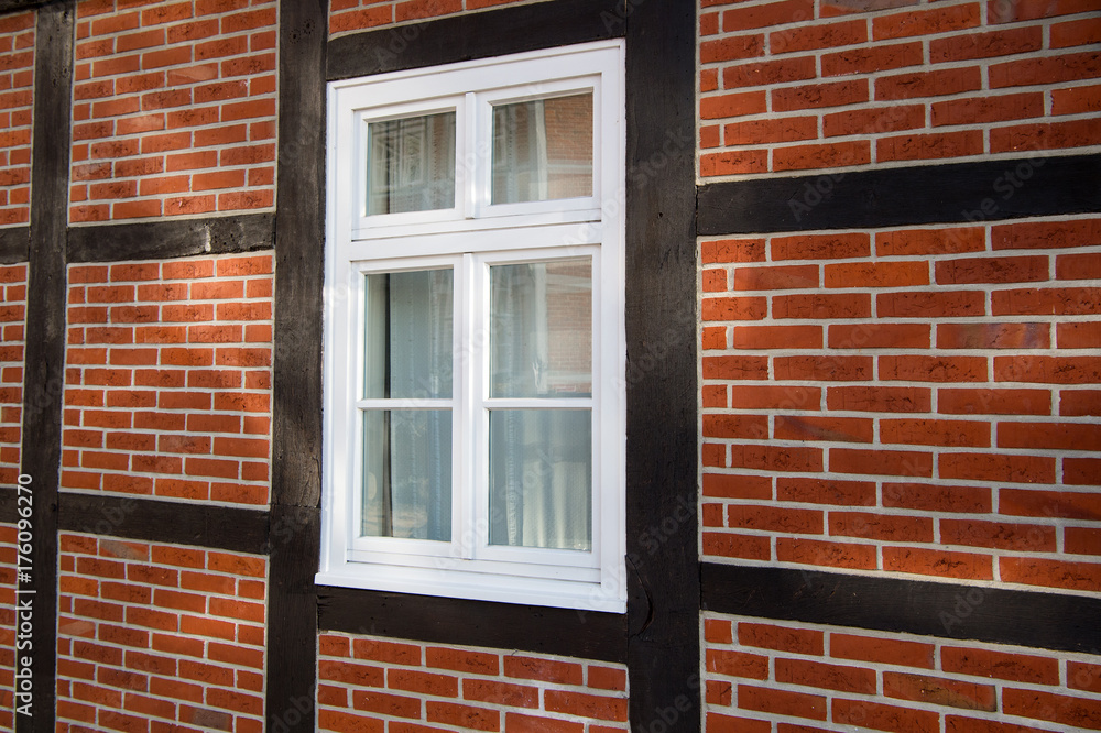 Fototapeta premium Window on red brick house wall