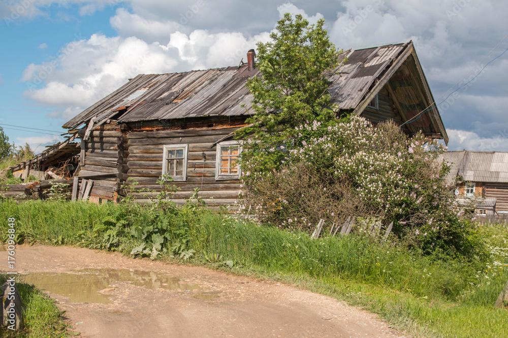 north Russian village Isady. Summer day, Emca river, old cottages on the shore, old wooden bridge. Abandoned building.