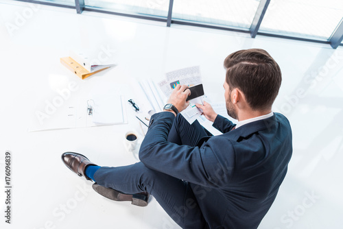 businessman with smartphone and papers