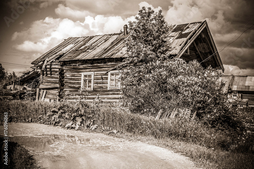 north Russian village Isady. Summer day, Emca river, old cottages on the shore, old wooden bridge. Abandoned building. photo
