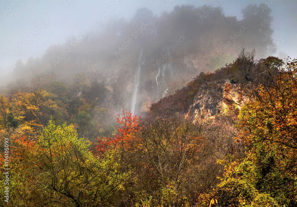 Beautiful landscape with mountain waterfall and colorful autumn forest