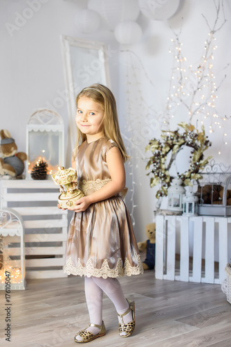 Merry Christmas and Happy Holidays! Cute little child girl play for the Christmas holidays indoors near Christmas tree