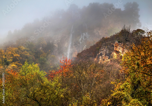 Beautiful landscape with mountain waterfall and colorful autumn forest © phadventure