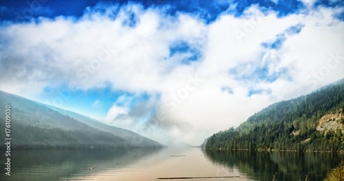 River amidst mountains against cloudy sky