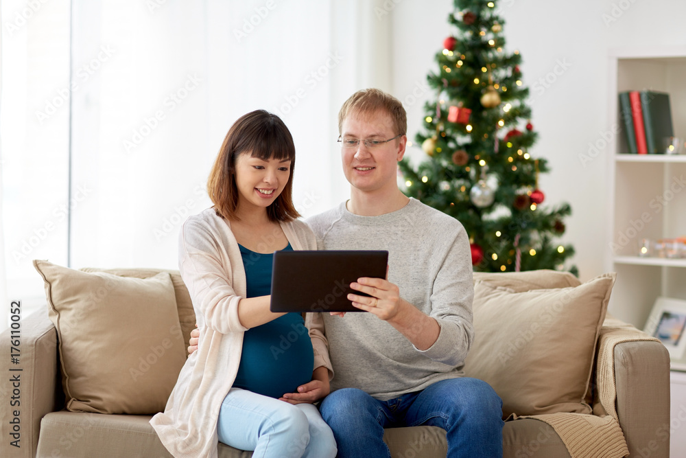 man and pregnant wife with tablet pc at christmas man and pregnant wife with tablet pc at christmas