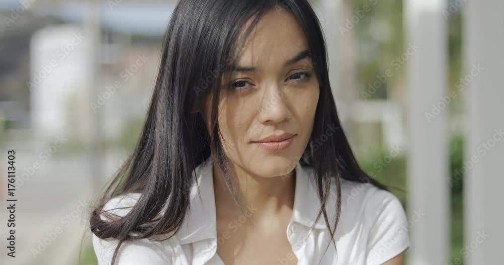 Headshot of ethnic young model posing in bright sunlight and looking playfully at camera while relaxing on vacation in resort. Headshot of ethnic young model posing in bright sunlight and looking playfully at camera while relaxing on vacation in resort.