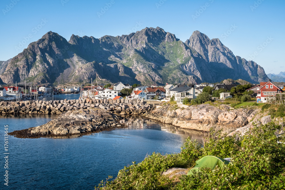 Scenic view from idyllic village with mountains at bright summer day in Henningsvaer, Lofoten, Norway