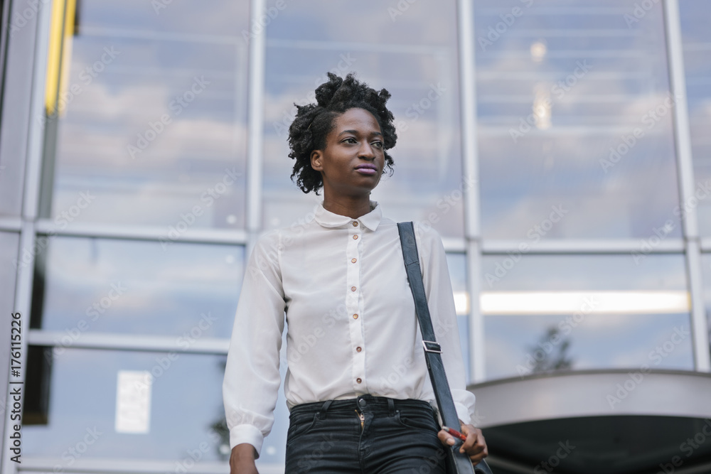 © VegterFoto/Stocksy - Black Woman leaving Office Building