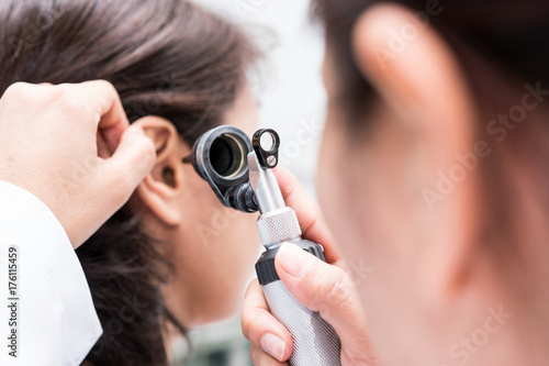 Doctor examined the patient's ear with Otoscope. Patient seem to have problems with hearing. photo