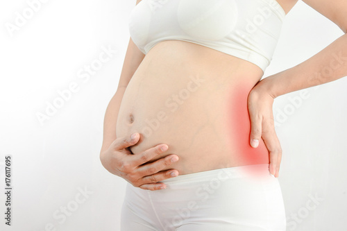 Pregnant woman with a strong pain massaging her back :Pelvic pain or lower back pain in pregnancy photo