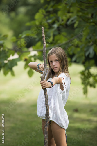 Girl playing with a handmade bow photo