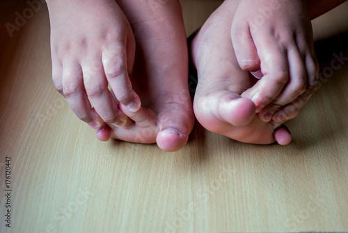 Both feet and hands on both sides of the boy on the wooden floor