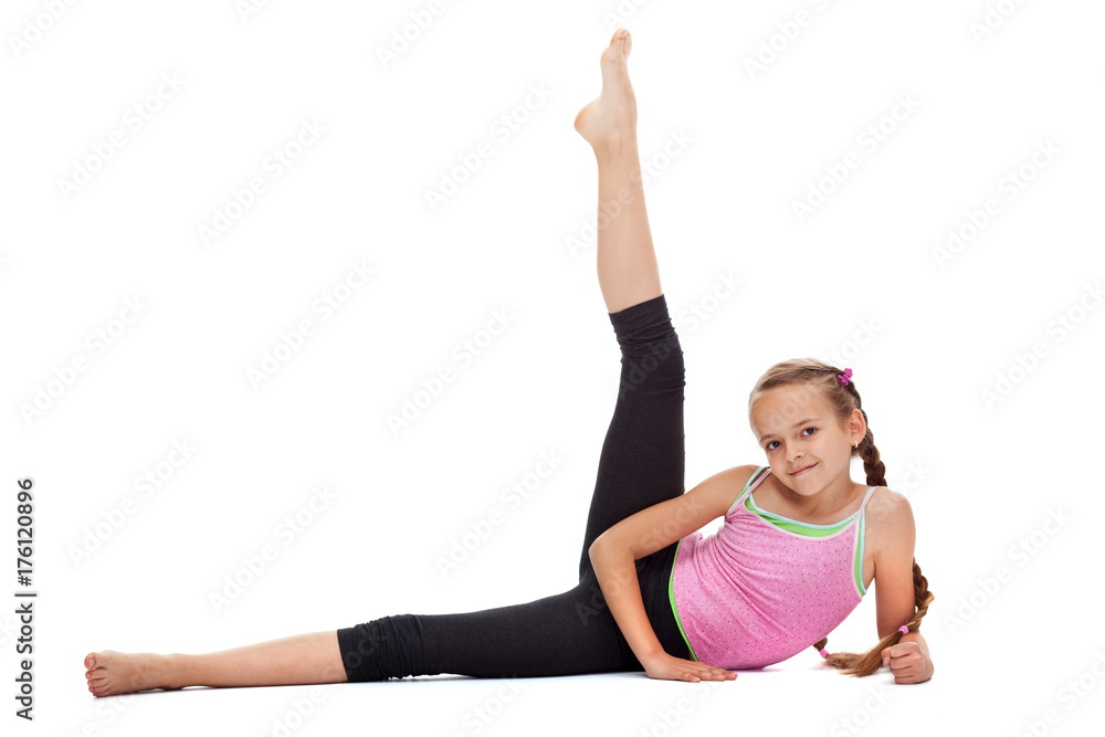 Young girl doing gymnastic exercises for leg strength and flexibility