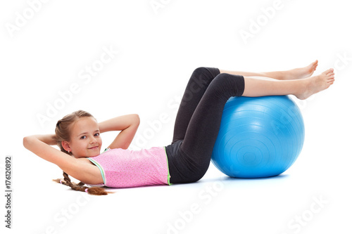 Young girl doing sit ups with a large gymnastic ball