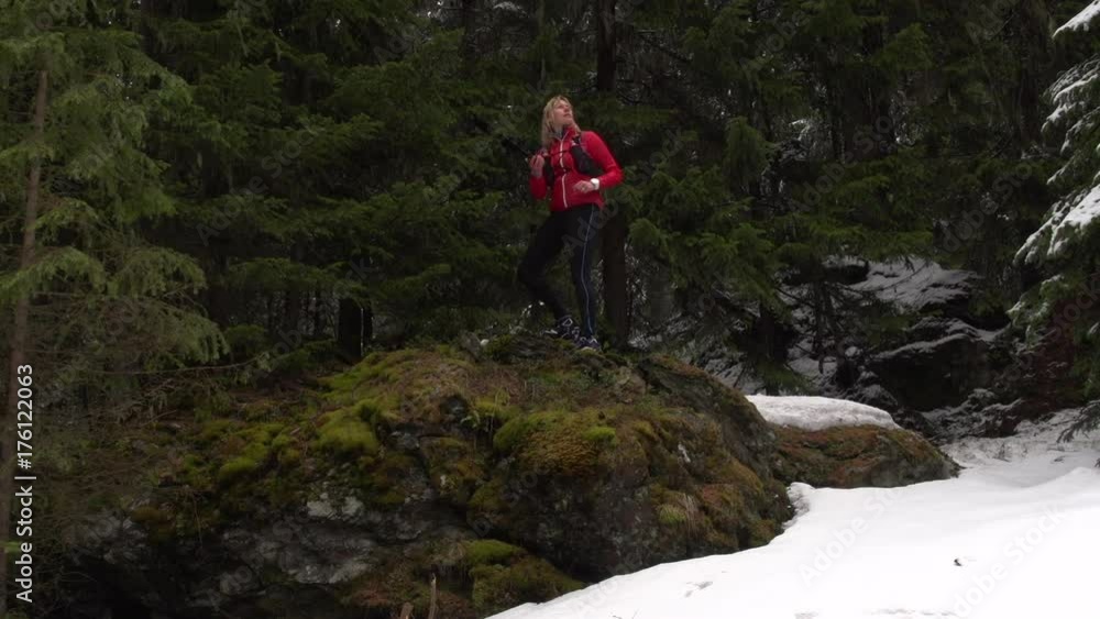 A woman Orienteering stops to check her navigational device. A woman Orienteering stops to check her navigational device.