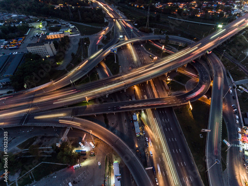Vertical top down aerial view of traffic on freeway interchange at night.