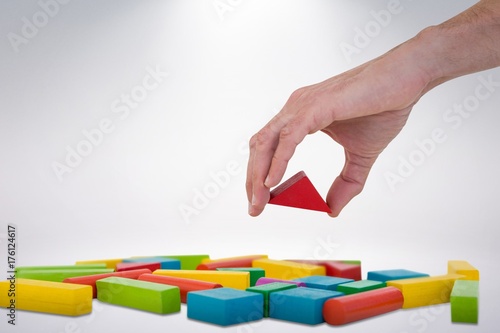 Composite image of cropped image of person arranging blocks
