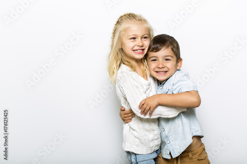 Cute girl 4-5 year old with brother posing in studio