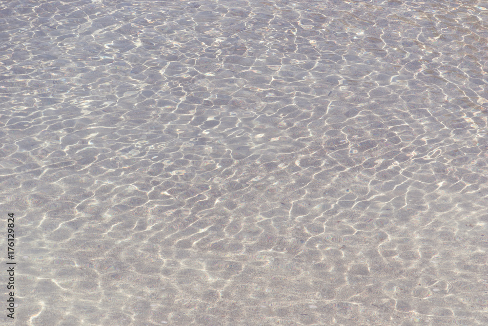 Refraction of light in clear water with small waves. Background.